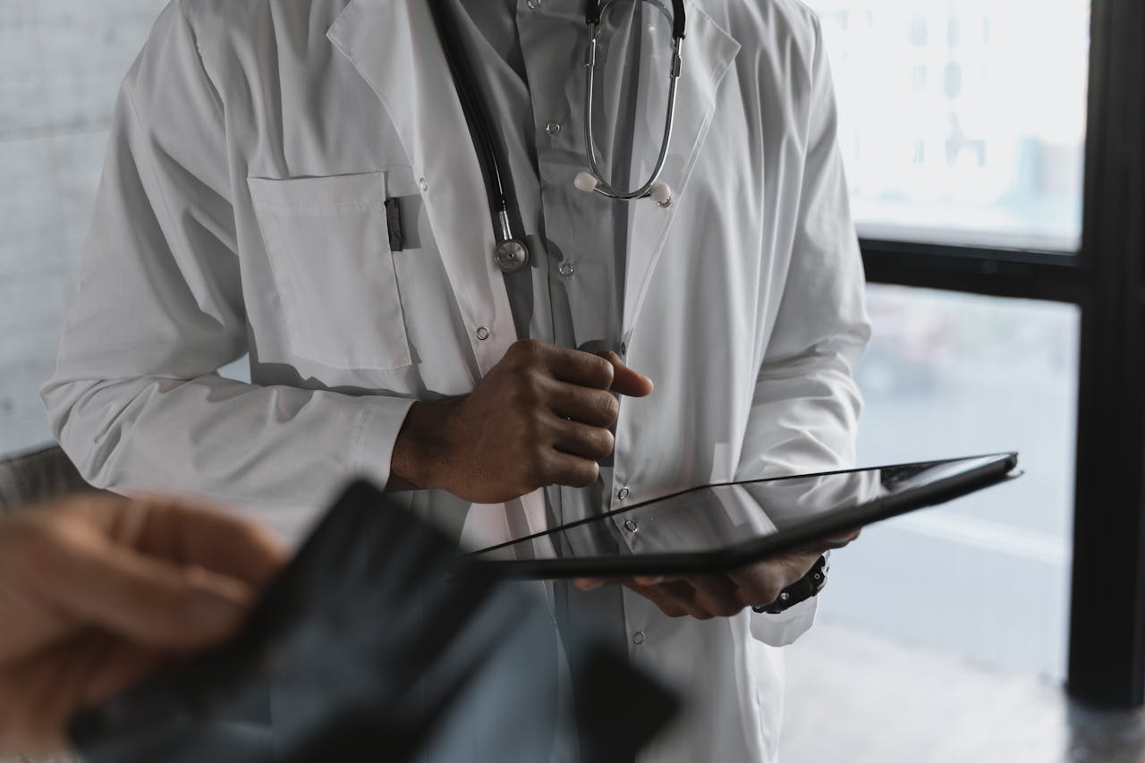 experience-img A professional medical practitioner holding a tablet, focused on work in a clinical setting.